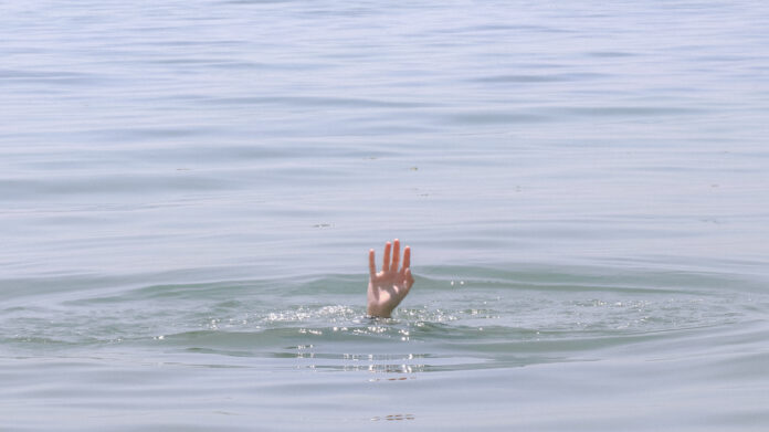 Person s hand above water