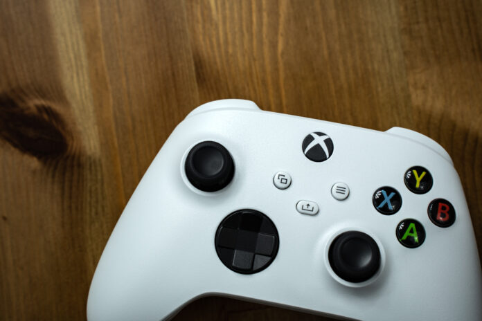 Close up shot of a white game controller on a wooden surface